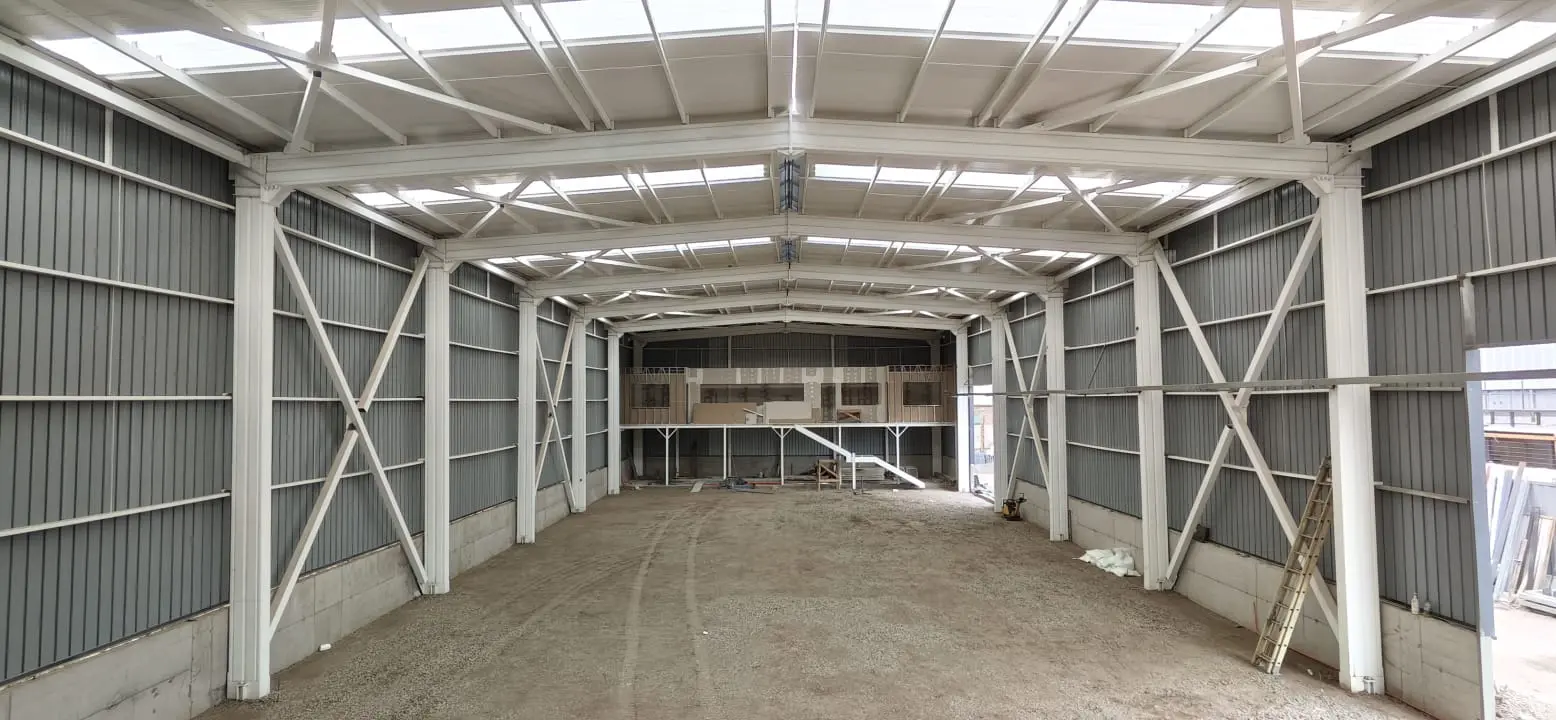 Interior de galpón industrial con estructura de acero, columnas y arriostramientos diagonales - Quilpué